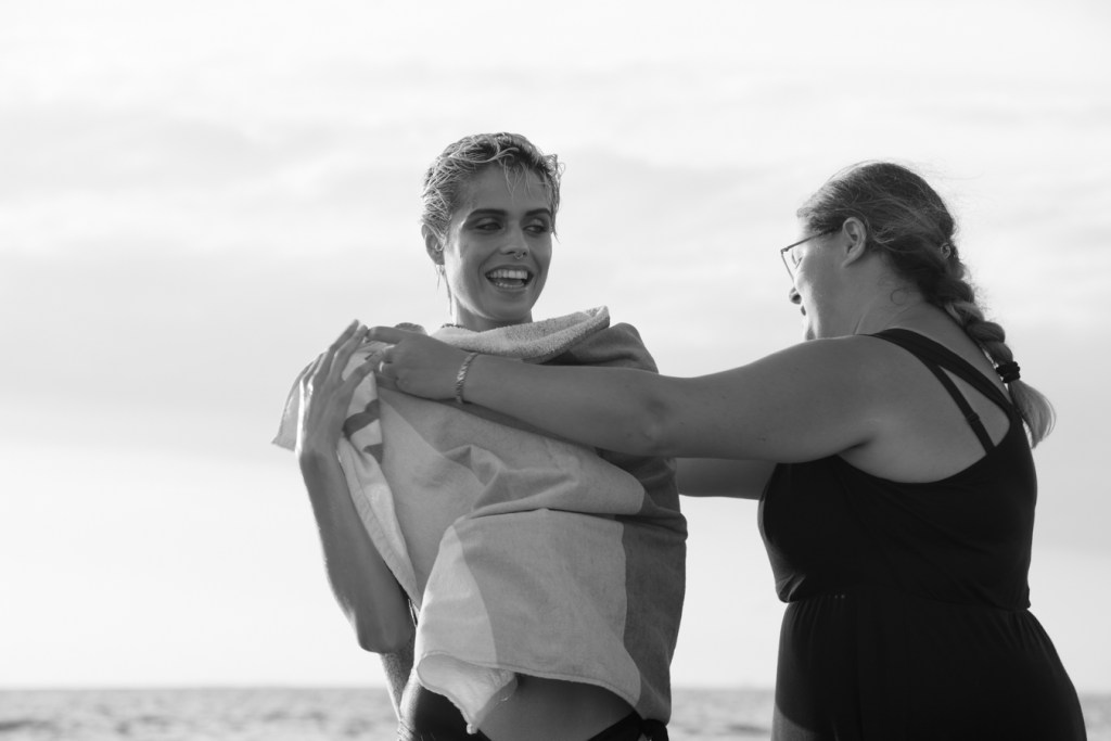 Silvia Biafora che copre Albachiara Gandolfo subito dopo la fine degli scatti sul litorale di Sabaudia per il workshop The Last Day of Summer a Sabaudia di Simone Passeri.